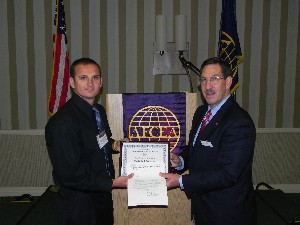 Pat Kelly (r), chapter vice president for education, presents Kuba J. Wasowski with the Bragunier Scholarship for his academic achievements and service as a member of the U.S. Marine Corps.