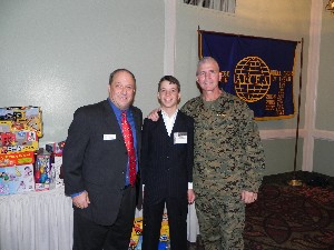 In December, Mike Savellico (l), chapter vice president for programs, joins his son Kevin (c) and Col. Richie in front of the Toys for Tots donations.