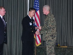 Loiselle (l) and Col. Richie (r) present a scholarship to officer candidate Jonathan Kim, a junior at the University of San Diego and a member of the Navy ROTC program. Kim served in Iraq for two tours of duty as a Navy SEAL medic, E-6.
