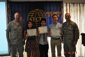 In June, Col. Daniel J. Birrenkott, USAF (l), chapter president, and Maj. Gen. Larry Wells, USAF (r), deputy chief of staff, U.S. Forces Korea, present scholarships to Melody Horbach, Jason Lamb (3rd from l) and Jakob Alejandre.