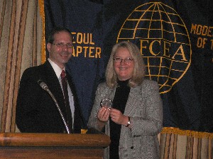 Seoul Chapter President Nathan Colodney presentes an AFCEA crystal paperweight to Cindy E. Moran, Defense Information Systems Agency, in appreciation for her support.