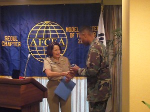 At the November meeting, Adm. Brown receives an AFCEA crystal paperweight from chapter president and U.S. Forces Korea (USFK) assistant chief of staff, J-6, Col. Greg Edwards, USAF, in appreciation for her support of the chapter.