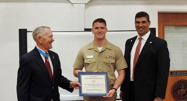 Midshipman Bradley William Reber receives his $4,000 scholarship from Col. Marm and Chapter President Lee Cantrelle at the ceremony in September. 