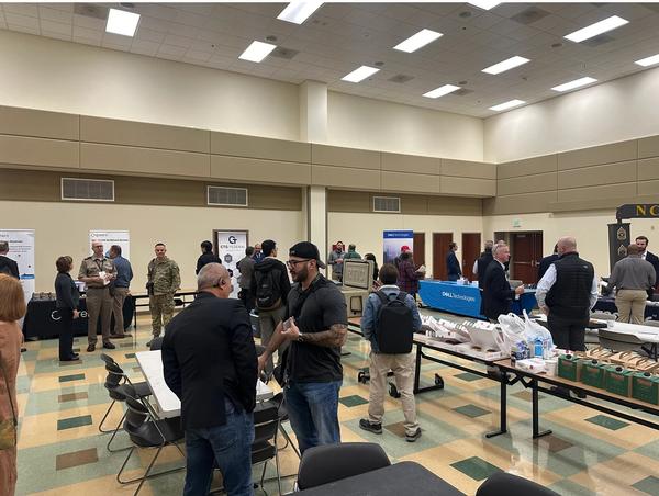 Sponsors and attendees network in the drill hall during the November event. 