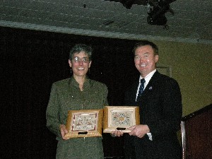 Col. Michelle Fraley, USA, NETCOM/9th ASC, accepts a token of thanks from Besselman in October.