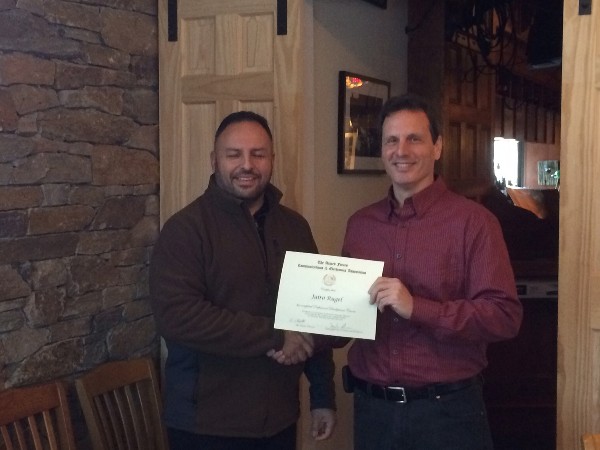 In February, Loda presents a certificate to Jairo Rugel.