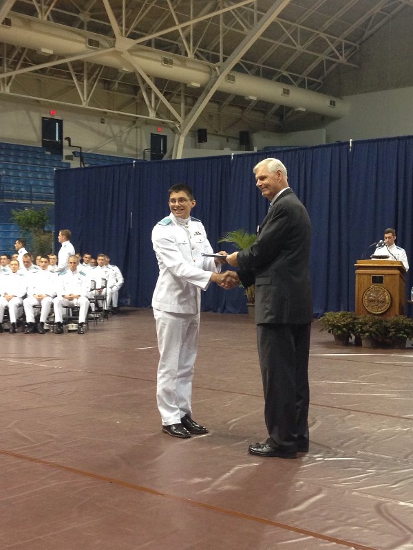 Midshipman Jose Delgado, USN, accepts his ROTC Honor Award from Pearsall at the awards ceremony in March. 