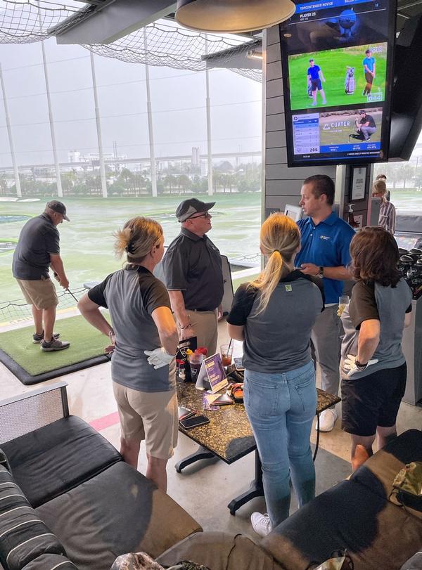 Representatives of event sponsors Microsoft and Venatore chat with participants at Topgolf Miami Gardens for the October event.