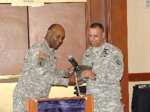 At the May luncheon, Col. Herb Newman, USA, chapter president (l), presents a chapter polo shirt to CSM Angel Febles, USA (r), keynote speaker.
