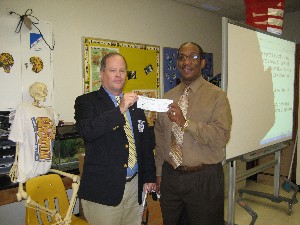 Billy Hogan (l), chapter vice president, presents a check for $1,000 to Alfonso Livingston, Norland Middle School, Miami Beach, Florida, in December. The check was part of the Science Teaching Tools program.
