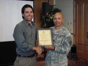 Col. Churchwell (l) presents a new corporate member certificate to Conrad Webber II on behalf of SatPhoneStore in November.