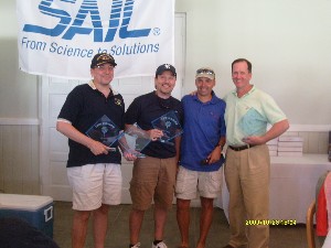 At the golf tournament and fundraiser, held in October, Col. Churchwell (2nd from r) presents the first-place trophy to Jose Adan Gutierrez (l), SAIC; Eric Garnier (2nd from l), Cambridge; and Steve Walker, SAIC.