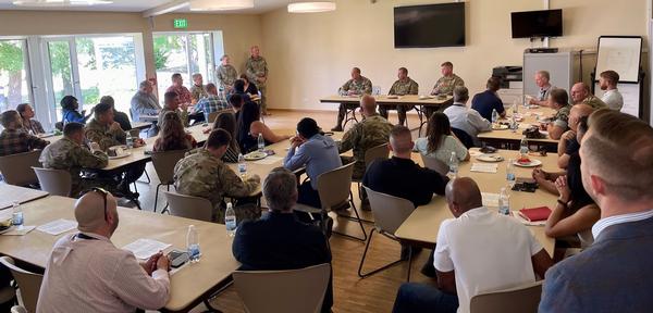 During the June event, luncheon attendees listen as guest speaker Col. Brent Skinner, USA, commander, Defense Information Systems Agency-European Field Office, discusses the importance of creating cyber partnerships and the advantages the Stuttgart area has to accomplish it. 
