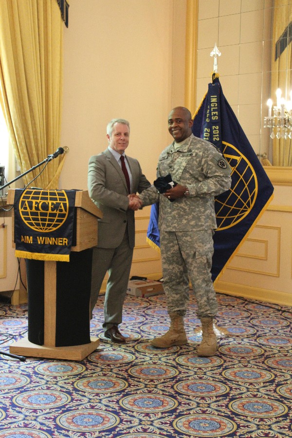 Roger Carpenter, chapter president presents Col. Richard Price, USA, commander of the Defense Information Systems Agency-Europe, with a chapter coin, shirt and plaque as tokens of appreciation for speaking at the June luncheon.