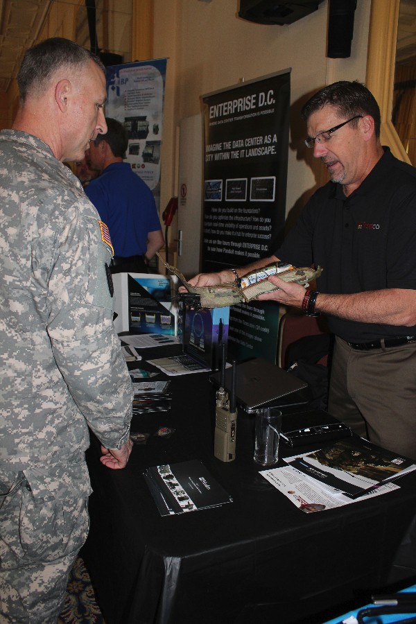 A Winter Tech Expo vendor showcases the company's offerings at an attendee in February.