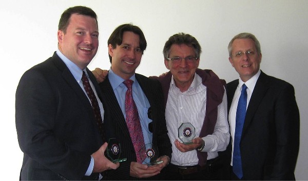 In April, Roger Carpenter (r), chapter president, presents chapter coins to Brendan Mahoney (l), Jeff Kietzmann (2nd from l) and Scully, all from Emerging Markets Communications.