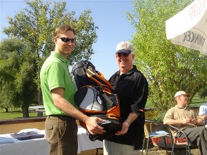 Jason Makowski (l) accepts one of the raffle items he won from Dr. Joseph Page Jr., chapter secretary and scholarship event organizer, at the September Golf Classic, which benefitted the chapter's scholarship fund.