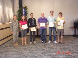 Col. Michelle Fraley, USA (l), commander, DISA-Europe, and chapter president, congratulates the winners of the chapter's annual scholarship awards, presented to high school seniors with outstanding technology presentations. The chapter awarded $10,000 in savings bonds to high school seniors from Patch High School and the International School of Stuttgart at the awards presentation, held in July. 
