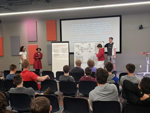 Students present their student-led solutions for architecting "Zero-Trust Networks" at a fictitious casino at the November event.