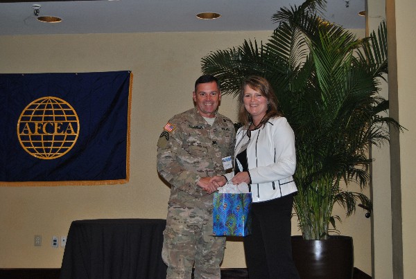 Chapter President Col. John Mclaughlin, USA, C4 operations division chief, United States Special Operations Command, presents a gift to guest speaker Deborah Woods, program executive officer, C4, Center for Special Operations Forces’ Acquisition, Logistics and Technology, at the chapter luncheon in August. 