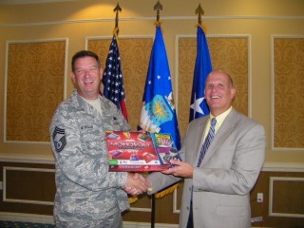 Ken Hirlinger (r), chapter president, recognizes Chief Master Sgt. Anthony Wheeler, USAF, Air Combat Command/A6X, twice during the July luncheon as an AFCEA Lifetime Member and the winner of the scholarship raffle. 