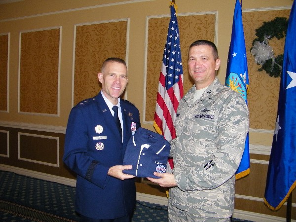 In December, Col. Glenn Powell, USAF (l), chapter vice president, presents a chapter polo shirt to Maj. Gen. Steven Kwast, USAF, director of requirements, Headquarters Air Combat Command, Joint Base Langley-Eustis, Virginia. 