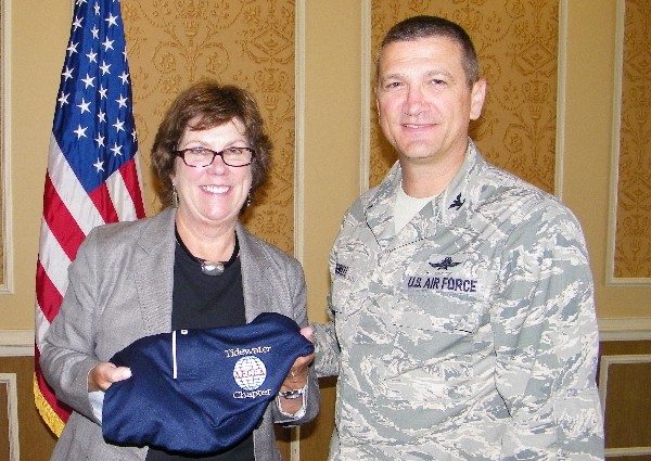 Chapter Vice President Col. Glenn Powell, USAF, presents June luncheon speaker Carroll McGillin, Cisco Systems, with a chapter polo shirt.