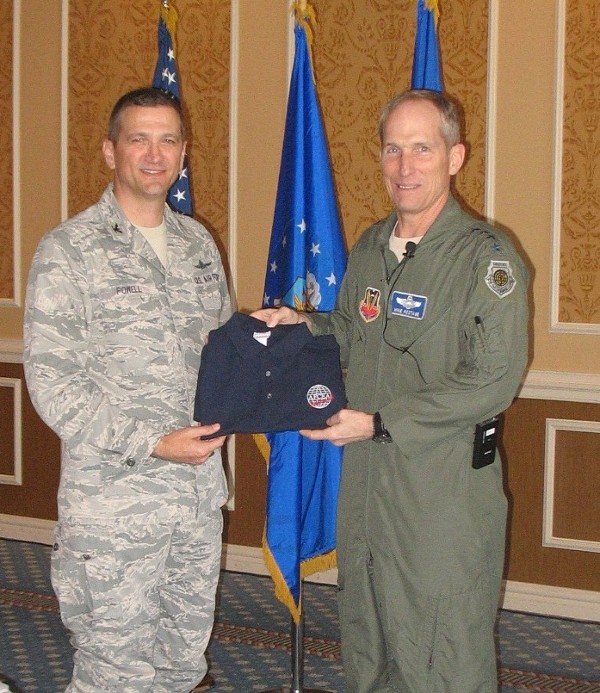 Col. Glenn Powell, USAF (l), chapter vice president, presents Gen. Mike Hostage, USAF, commander, U.S. Air Combat Command, with a chapter polo shirt following the general's speech at the April luncheon.