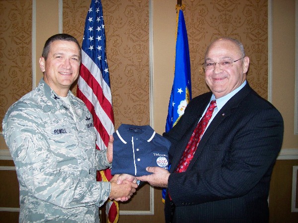 Col. Glenn Powell, USAF (l), chapter president, presents Dr. Albert Mitchum Jr., the political adviser to the commander of Air Combat Command, with a chapter polo shirt following his speech at the November meeting.