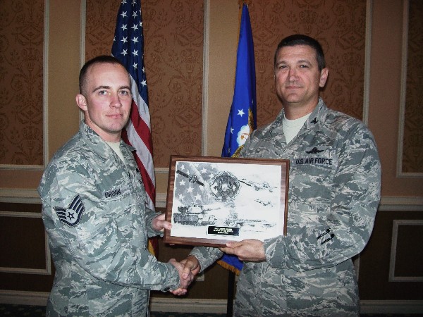 Col. Glenn Powell, USAF (r), chapter president, presents a chapter plaque to Staff Sgt. James Brown, USAF, AFCEAN of the Month for October.