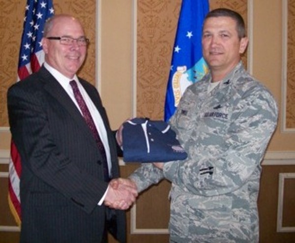 In March, Col. Glenn Powell, USAF, chapter president, presents Don Hudson, technical director, 480th Intelligence, Surveillance and Reconnaissance Wing, Langley Air Force Base, with a chapter shirt.