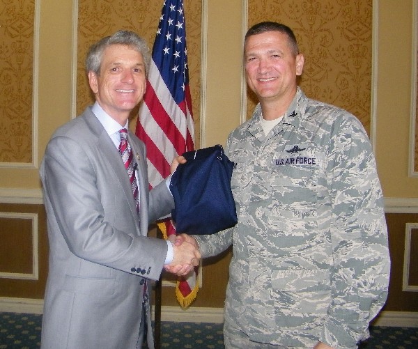 Chapter President Col. Glenn Powell, USAF (l), presents Rep. Scott Rigell (D-VA) with a chapter shirt for speaking at the May luncheon.