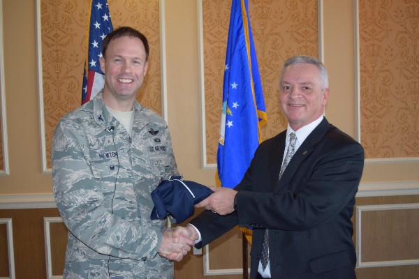 Chapter Vice President Randy Martin (r) presents Col. Harvey Newton, USAF, deputy director of operations, Air Combat Command (ACC), Langley Air Force Base, Virginia, with a polo shirt at the December luncheon.