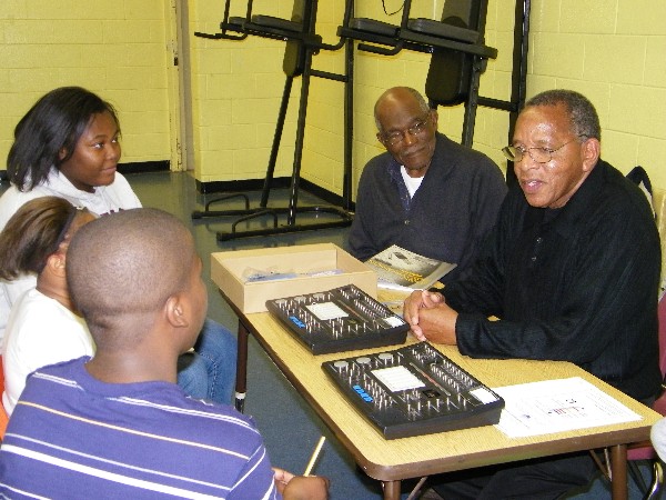 Electrical engineers Herbert Dublin and Willie Mitchell volunteer to teach Lindsay Middle School UAV students basic electronics principles in April.