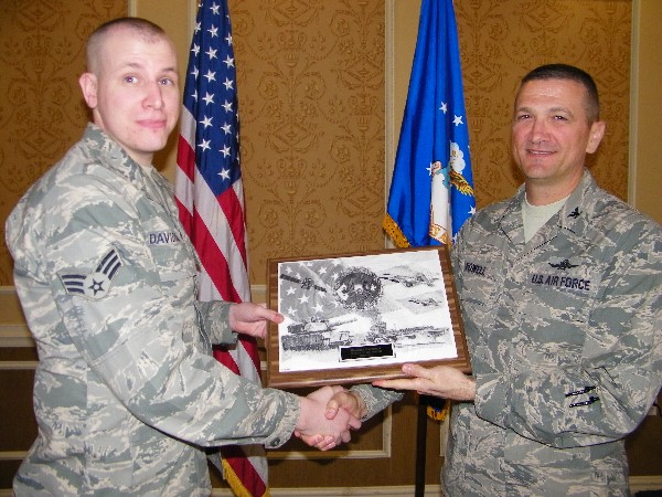 Col. Powell (r) recognizes Senior Airman Joel Davidson, USAF, 10th Intelligence Squadron, for his selection as the March AFCEAN of the Month recipient.