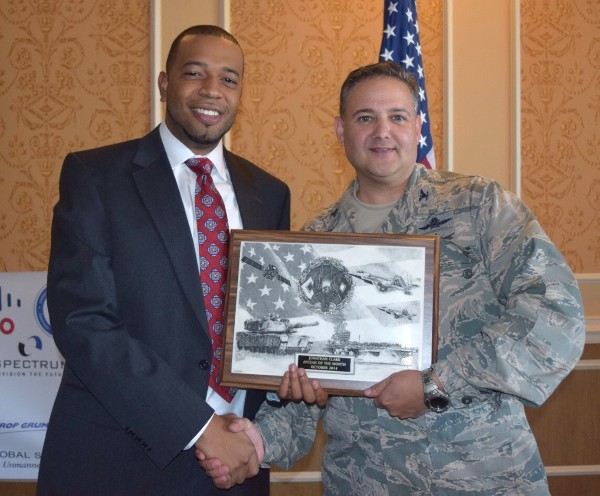 At the October chapter luncheon, Johnathan Clark (l) receives a plaque as October AFCEAN of the Month for his support in working the chapter booth at multiple events.