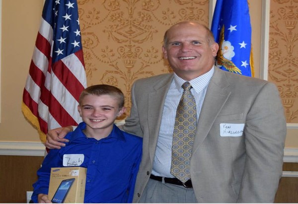 Ken Hirlinger of General Dynamics congratulates science fair winner Zachary Tallman during the August event.