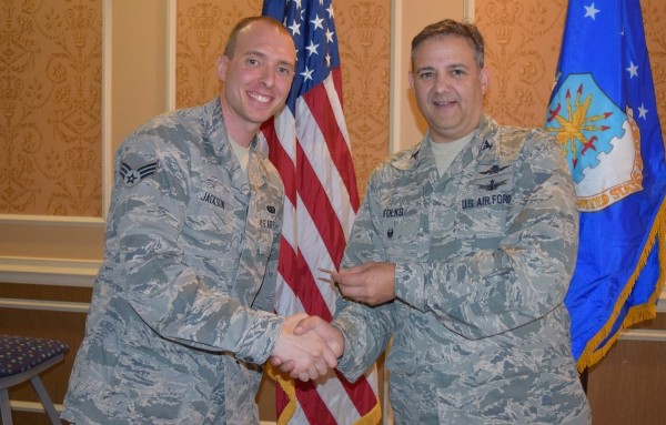 Col. Folks (r) congratulates the chapter's November Young AFCEAN of the Month, Senior Airman James Jackson, USAF, at the luncheon.