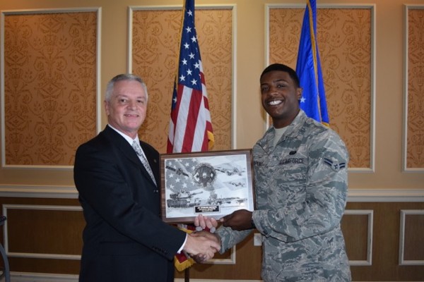 Martin awards a plaque to December AFCEAN of the Month Airman 1st Class Sterling Hopkins, USAF.