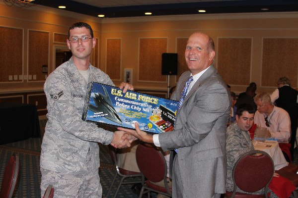 In June, Ken Hirlinger (r), chapter president, presents a U.S. Air Force poker chip set to raffle winner Airman 1st Class Craig Maxson, USAF, 10th Intelligence Squadron.