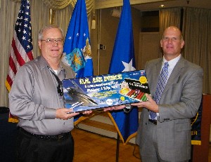 Hirlinger (r) presents Bruce Bobbitt, Air Combat Command/A-6, with a prize from the scholarship raffle, which gathers funds to support local high school and college students.