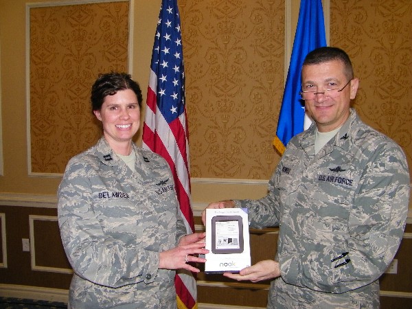 Capt. Colleen Delawder, USAF, 10th Intelligence Squadron, receives a Nook e-reader from Col. Powell that was given away during scholarship raffle at the March luncheon.