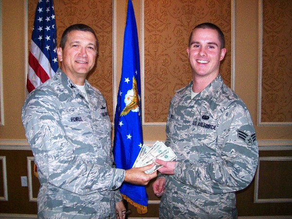 Senior Airman Jacob Bell, USAF (r), 633rd Communications Squadron, takes home the $80 jackpot from the membership drawing presented by Col. Powell in November. This drawing is held each month with the pot starting at $10 and grows each month by $10 until there is a winner.
