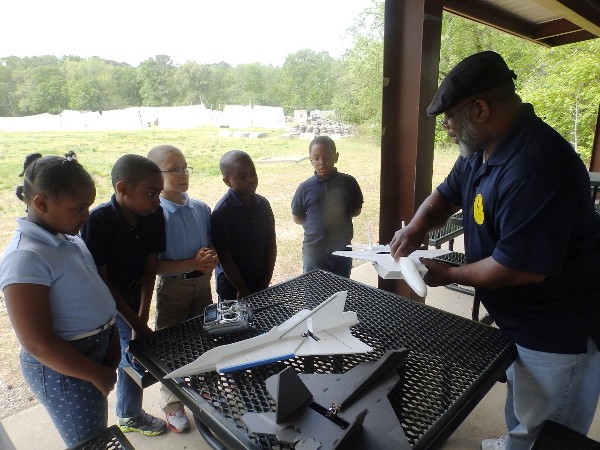 Aaron Mills of the 480th Intelligence, Surveillance and Reconnaissance Wing explains the aerodynamic effects of lift, drag, thrust, weight and balance to (l-r) Ryan Mack, Isaiah Irving, Maleik Waldo, Jayden Perry and Naphish Washington in May.