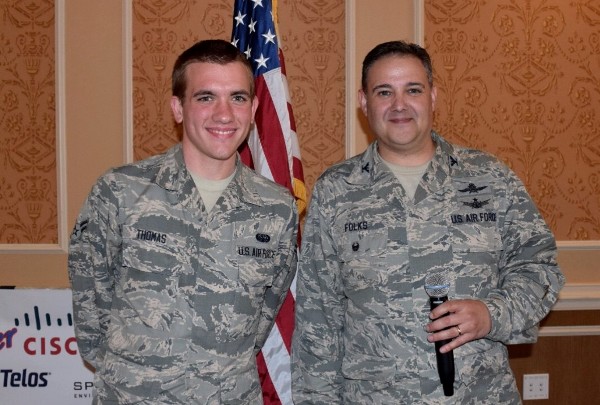 Airman 1st Class Jacob Thomas, USAF (l), November's Young AFCEAN of the Month, is honored by Col. Folks at the November luncheon for the Young AFCEANs' support of the Tabb High School CyberPatriot team.