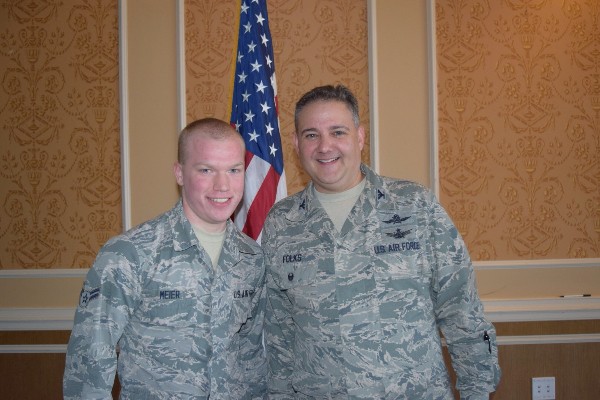Airman 1st Class Kyle Meier, USAF (l), Air Combat Command Communications Support Squadron, the February Young AFCEAN of the Month, receives a chapter President's Coin from Col. Folks in recognition of his outstanding chapter support.