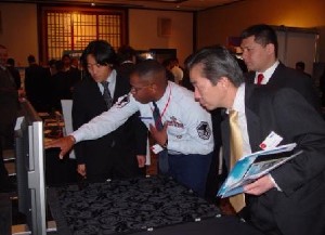 Master Sgt. Ron Parks, USN (c), DISA-PAC Japan Field Office, explains DISAs information systems and services to AFCEA Tokyo participants in January.