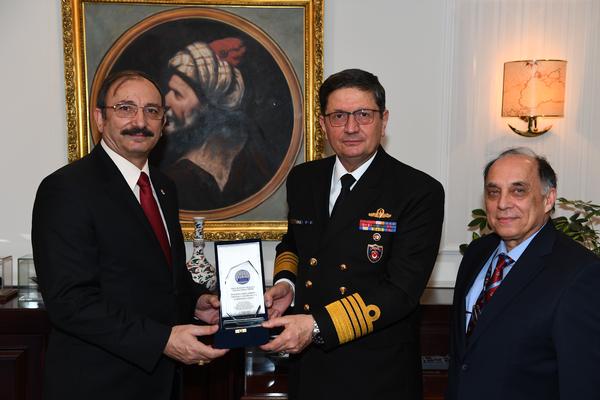 Kamil Zafer Selcuk, chapter president (far l), and Zafer Betoner, chapter vice president (far r), present the visiting plaque to Adm. Adnan Ozbal, commander, Turkish Naval Forces, as a token of appreciation during their February visit. 