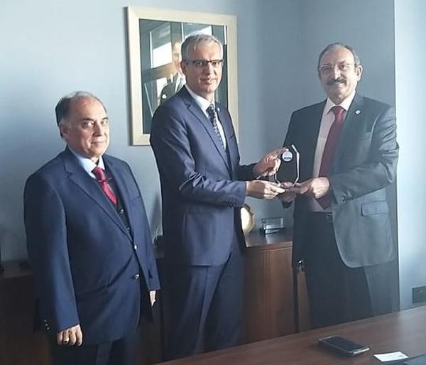 Capt. Kamil Zafer Selcuk, TUN (Ret.), chapter president (r), and Capt. Zafer Betoner, TUN (Ret.), chapter vice president, present a memento of their visit to SDT Inc. and Ömer Korkut, general manager (c).