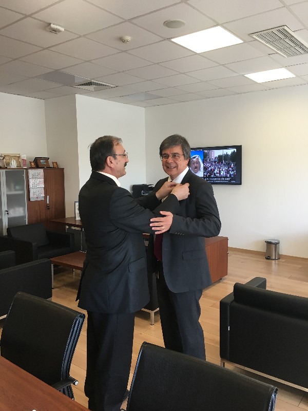 Chapter President Kamil Zafer Seljuk (l) secures Y. Suat Bengur's lifelong membership pin to his lapel in May.